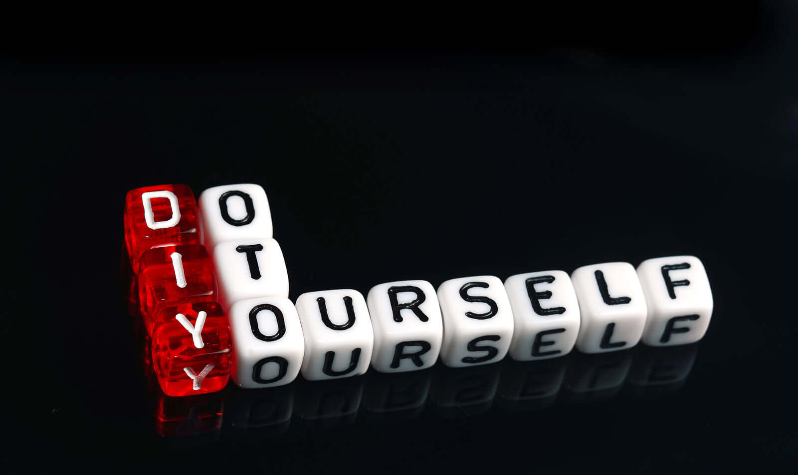 DIY yourself text blocks on a reflective surface, representing the DIY culture and creativity.