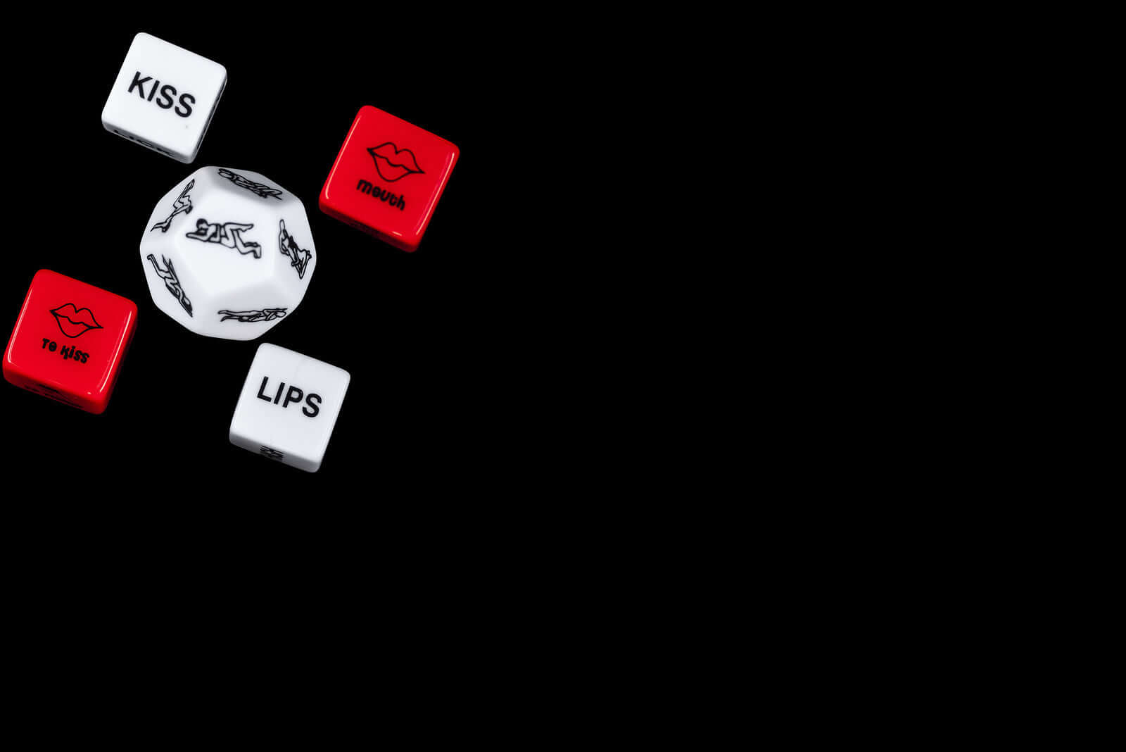 alt_tag: Essentials, Novelties and Games - playful dice for intimate fun, including prompts like KISS and LIPS.