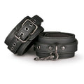 Black ankle cuffs for bondage with adjustable strap and metal chain for control and versatility.