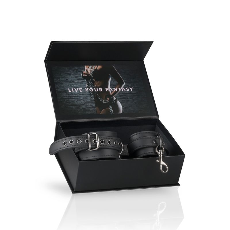 Black ankle cuffs for bondage inside a stylish box with the phrase 'LIVE YOUR FANTASY' on the lid.