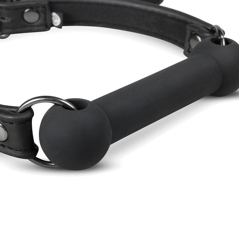 Close-up of a silicone bit gag for pony play with adjustable head strap, black silicone and metal clips.