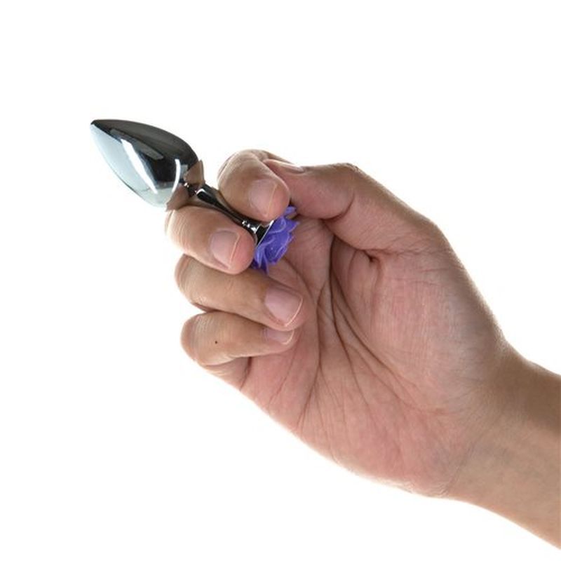Hand holding a Purple Rose 3in Metal Butt Plug, showcasing its tapered design and metallic finish for pleasure.