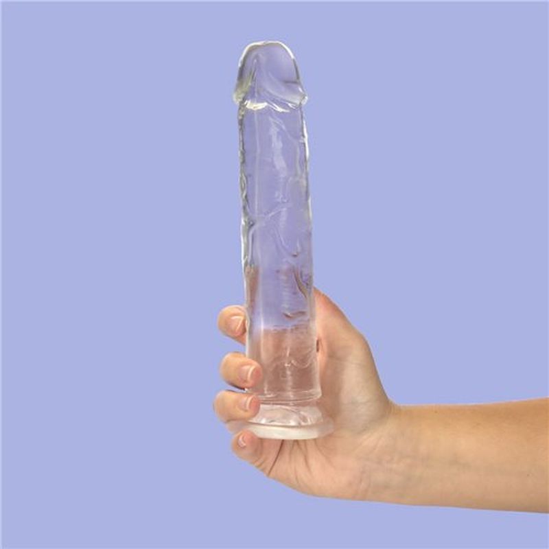 9 inch clear crystal dildo held in a hand against a soft purple background, showcasing its lifelike textures.