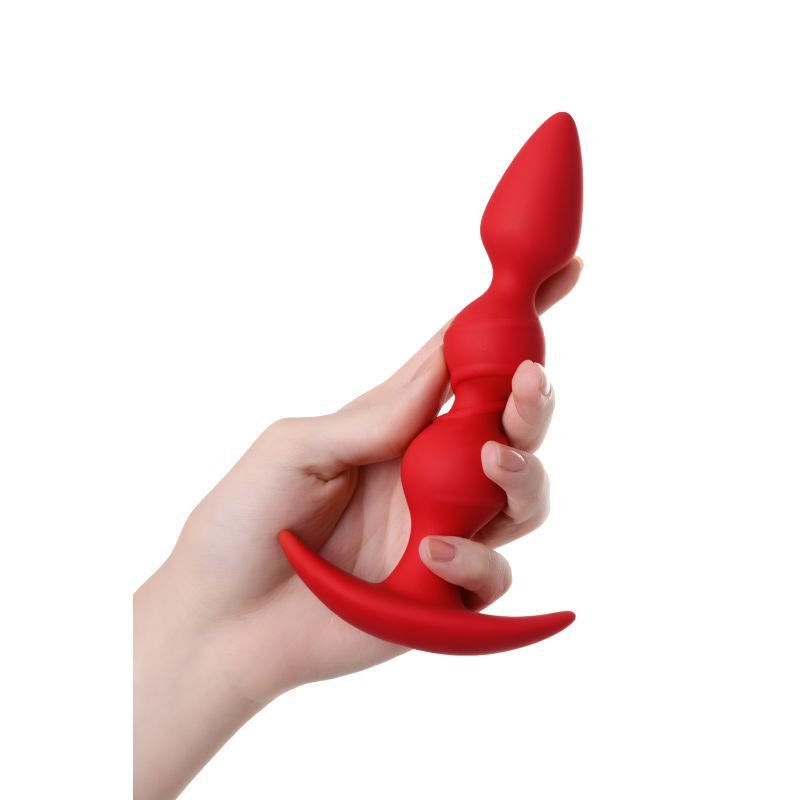 Hand holding a red silicone anal plug trio with three balls for intense stimulation.