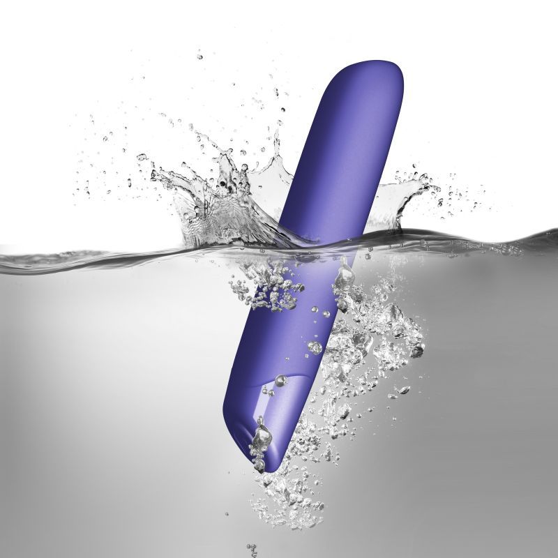 SugarBoo Very Peri vibrating bullet vibe splashing in water, showcasing its sensory touch finish and sleek design.