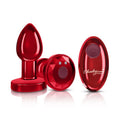 Cheeky Charms red rechargeable vibrating butt plug with remote, featuring a tapered design and stunning gemstone base.