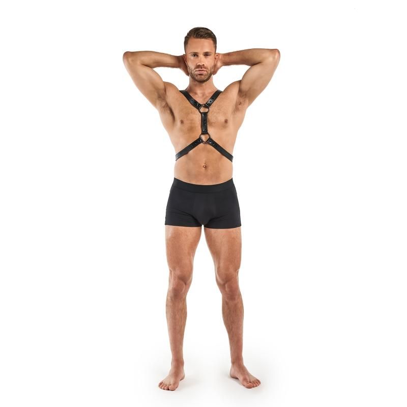 Man wearing a black adjustable BDSM harness made of faux leather, showcasing its fit for ultimate fantasies.