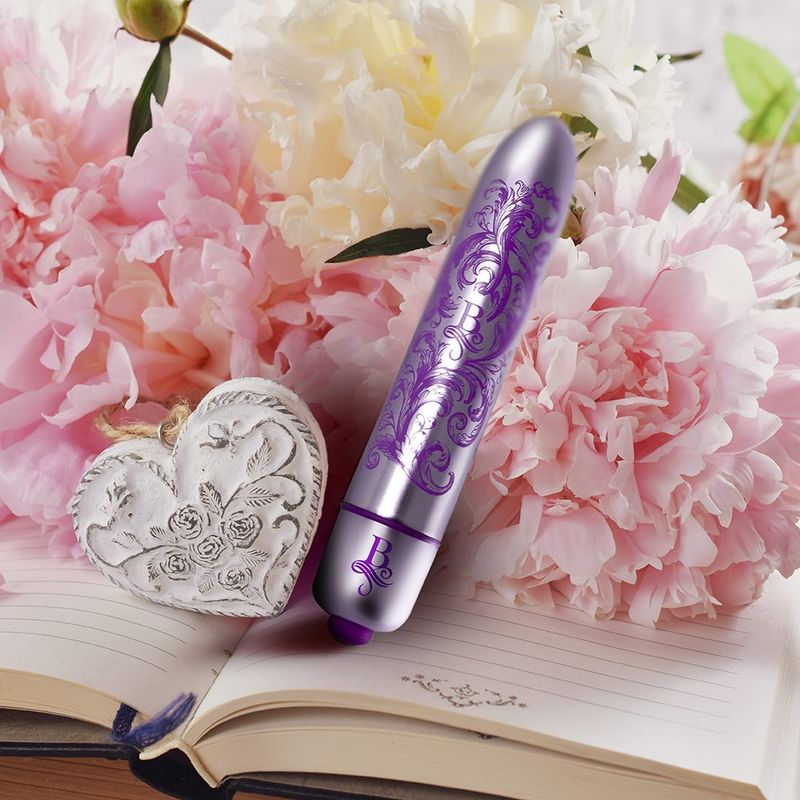 discreet waterproof bullet vibrator alongside flowers and a decorative heart on an open notebook.