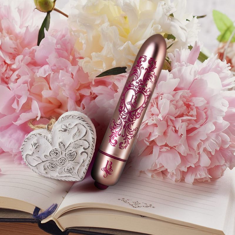 Boudoir Promenade Bullet, a stylish waterproof bullet vibrator next to flowers and a decorative heart.
