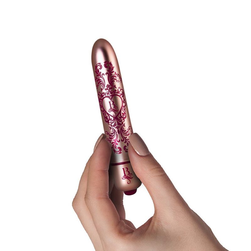 Waterproof bullet vibrator held in hand, showcasing ornate design and sleek finish.