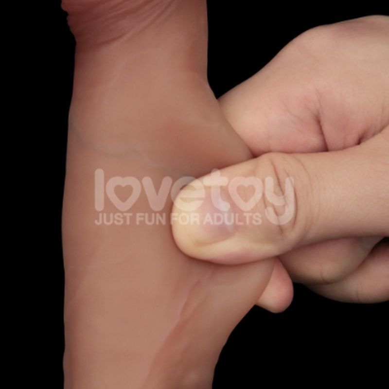 Close-up of a hand squeezing a dual layer silicone dildo, showcasing its realistic texture and flexibility.