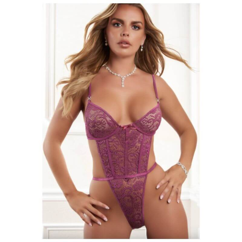 Model wearing an open back lace teddy in purple with adjustable straps and intricate lace design.