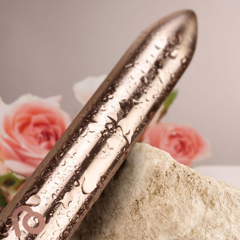 Golden Rose rechargeable bullet vibrator with a sleek design and water droplets, surrounded by delicate roses.