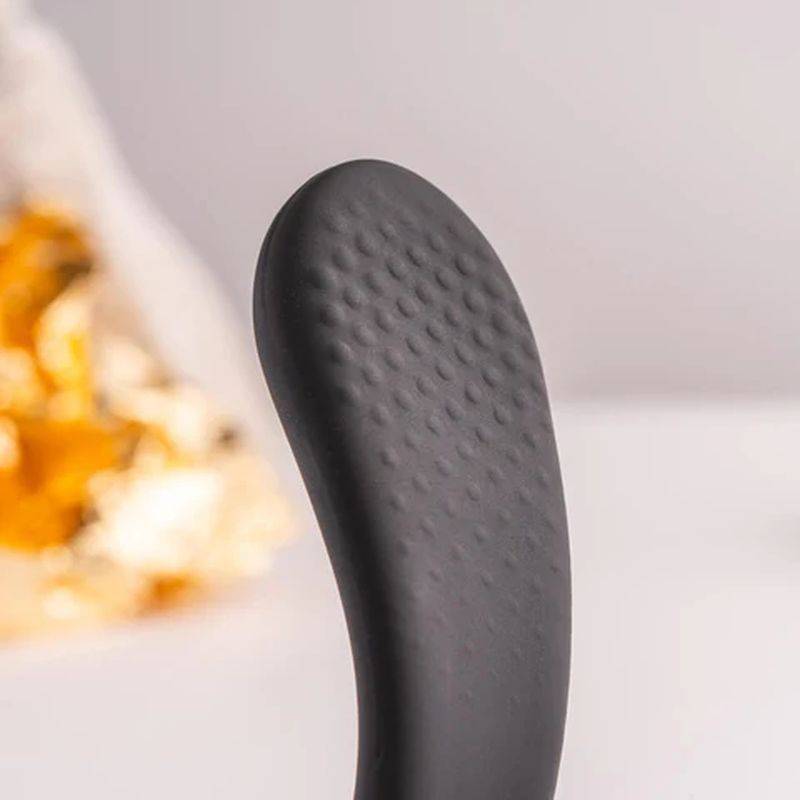 Close-up of a textured silicone head of a cock and ball vibrator for intimate stimulation.