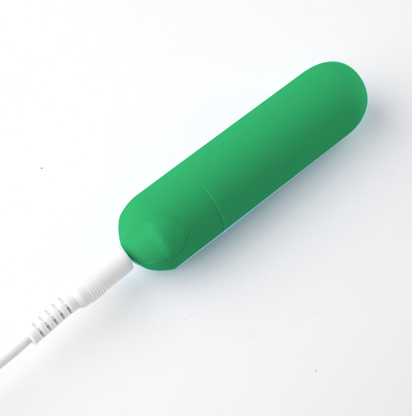 USB rechargeable mini bullet vibrator in emerald green with a silicone coating and charging cable.
