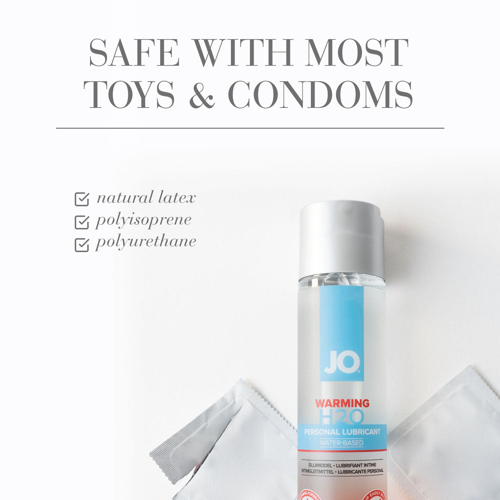 JO H2O Warming Lube - 120 mL - Water Based Warming Lubricant bottle with toys and condoms background.