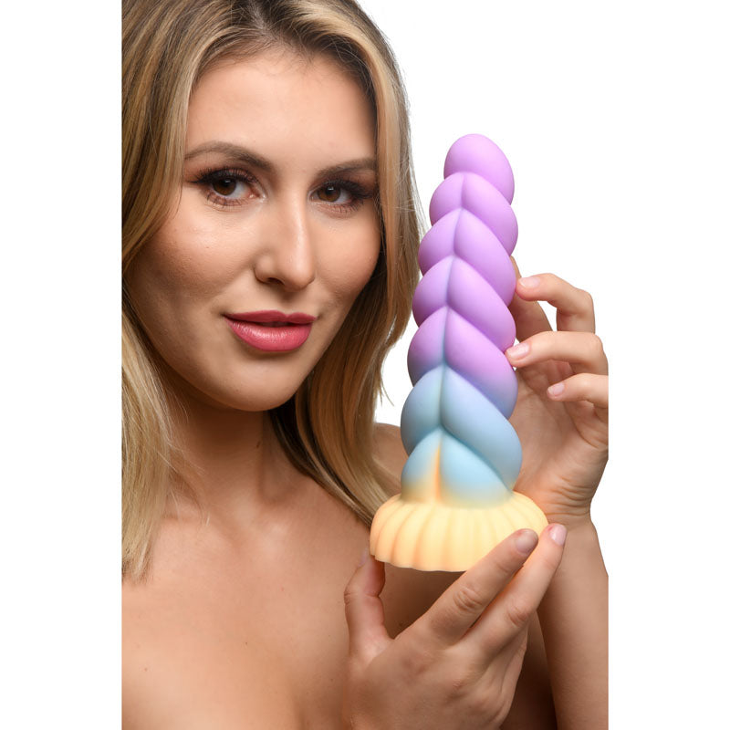 A person holding the Creature Cocks Mystique Silicone Unicorn Dildo - 21 cm Fantasy Dildo, showcasing its colorful design.