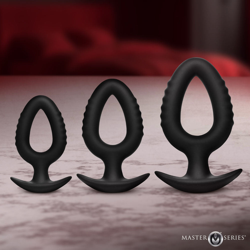 Master Series Pop Plugs -  Anal Plug Trainer Set - Set of 3 Sizes displayed on a table, made from premium body-safe silicone.