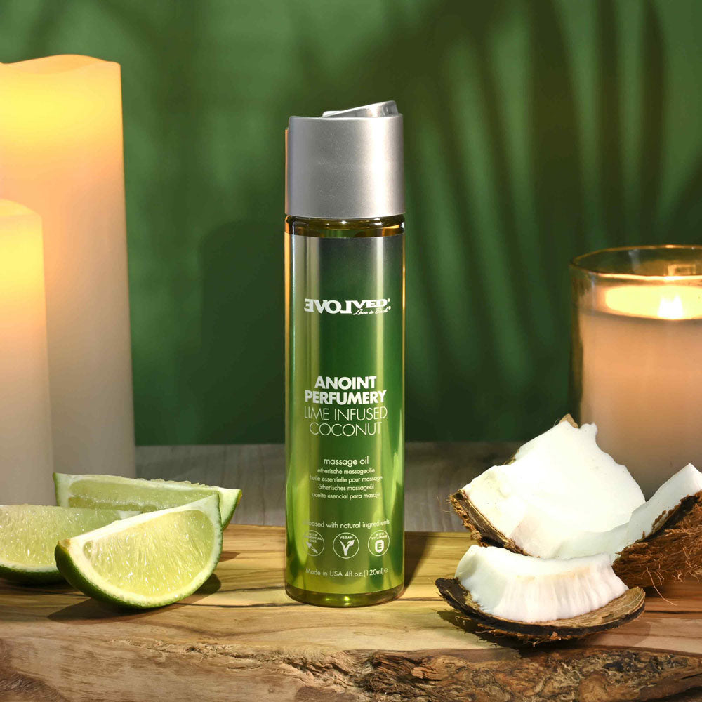 Evolved ANOINT PERFUMERY - Lime Infused Coconut - Lime Infused Coconut Massage Oil - 120 ml Bottle on a wooden table with limes and coconut.