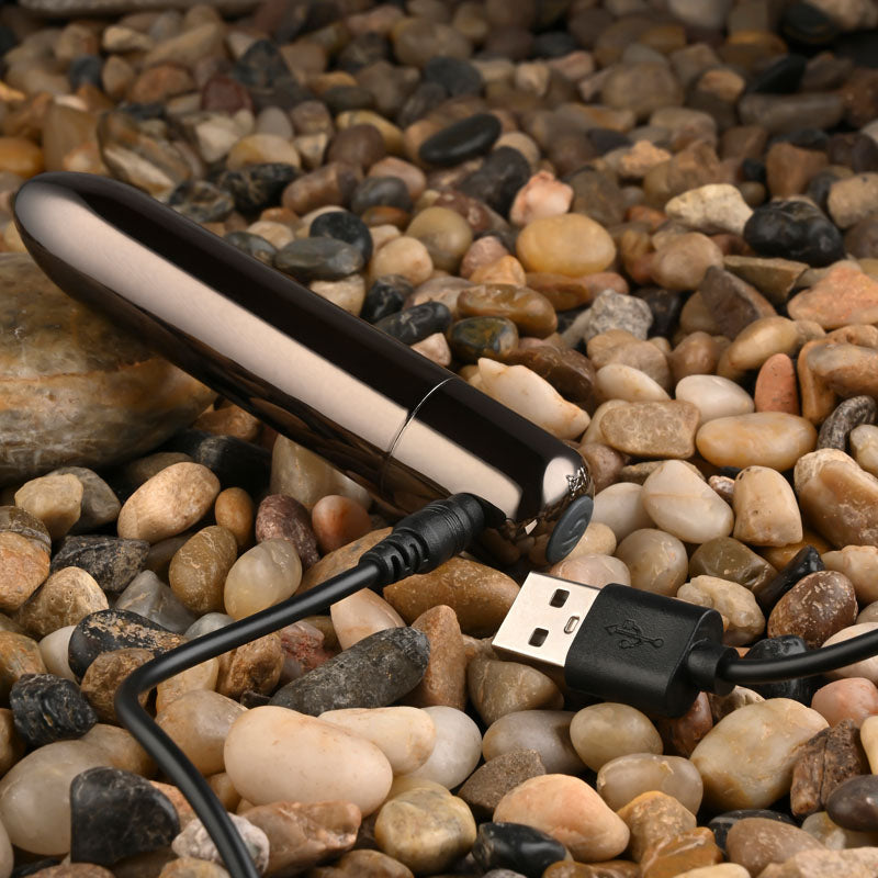 Evolved REAL SIMPLE - Black 10 cm USB Rechargeable Bullet charging on pebbles, sleek and discreet for intimate essentials for her.