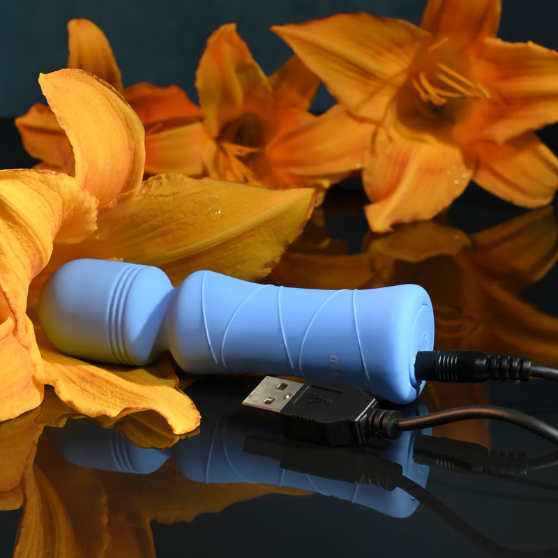 Evolved Out Of The  -  10.5 cm USB Rechargeable Mini Massager Wand next to orange lilies, showcasing its elegant design.