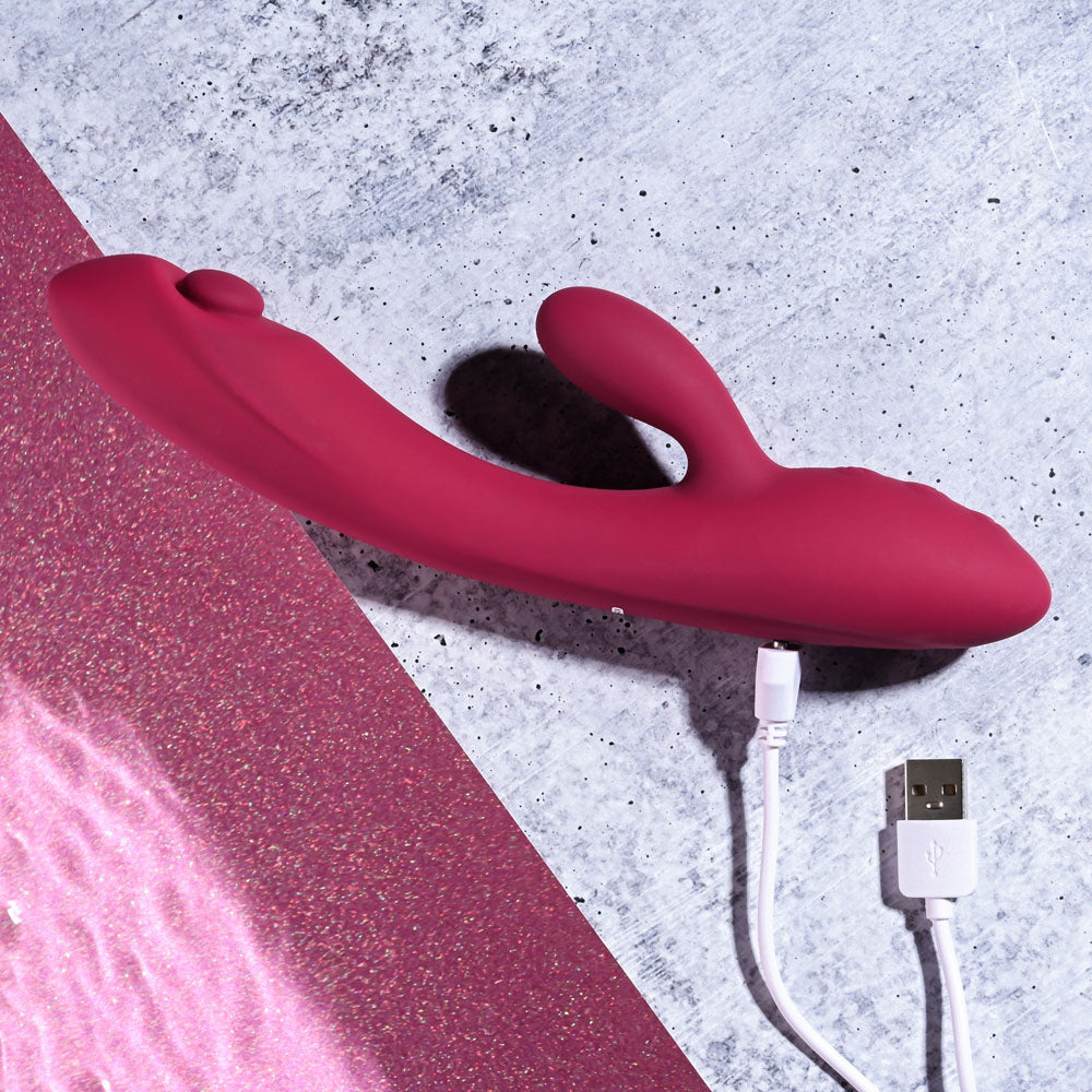 Evolved JAMMIN' G - Burgundy 20.1 cm USB Rechargeable Rabbit Vibrator on a textured surface with a USB cable.
