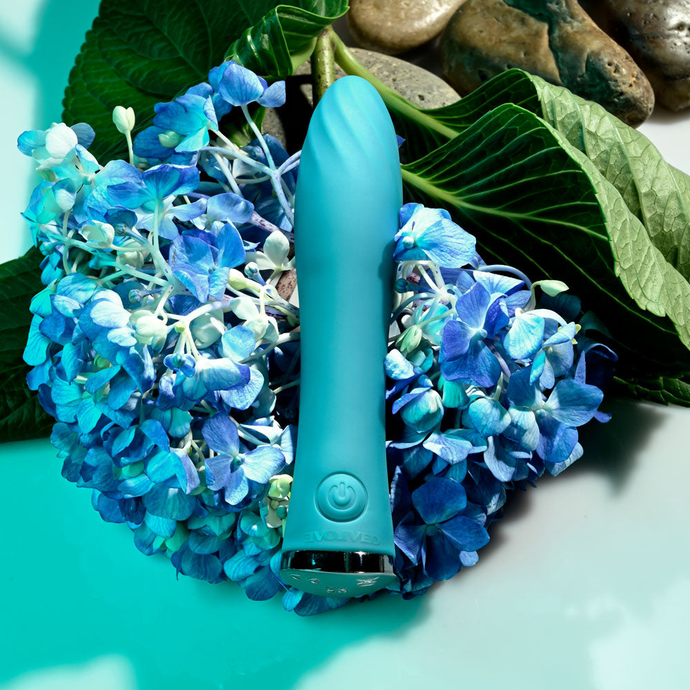 Evolved ULTRA WAVE - 13 cm USB Rechargeable Mini Vibrator surrounded by blue flowers for intimate essentials for her.