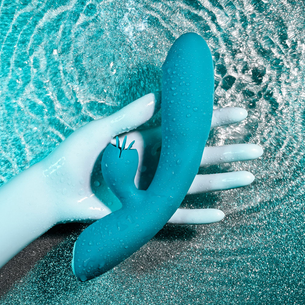 Evolved FIERCE FLICKER -  19.5 cm USB Rechargeable Rabbit Flicker Vibrator in a hand under water, showcasing its sleek design.