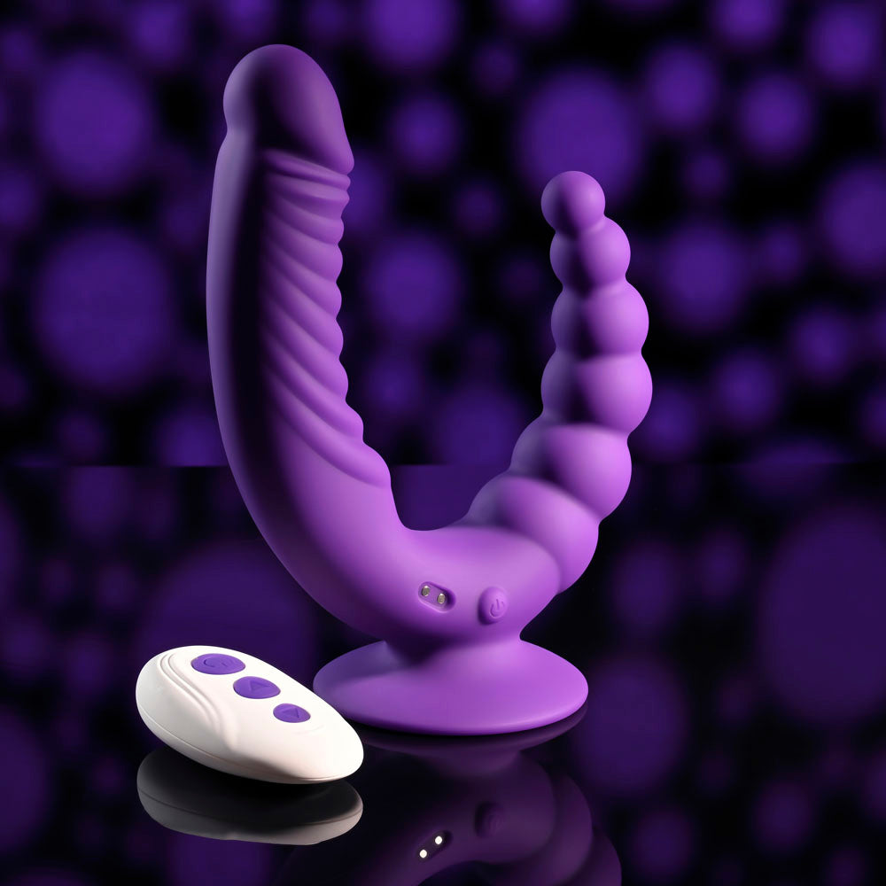 Evolved THE RIDER - USB Rechargeable Double Ended Vibrator with Wireless Remote next to its remote on a reflective surface.