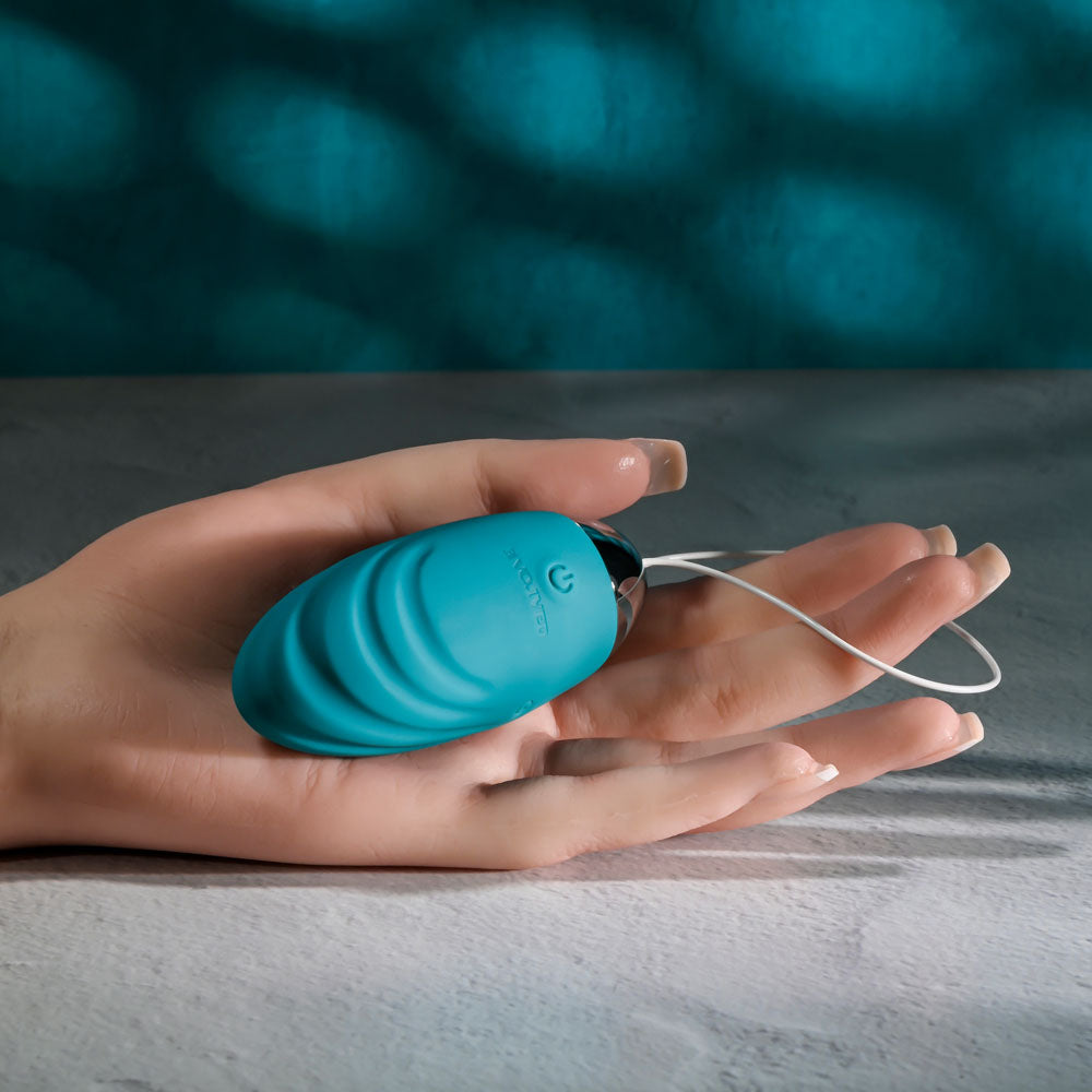 remote control vibrating egg in hand, USB rechargeable and designed for discreet pleasure.