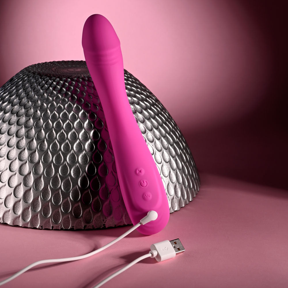 Evolved SUGAR RUSH - 21.6 cm USB Rechargeable Vibrator charging next to a metallic surface.