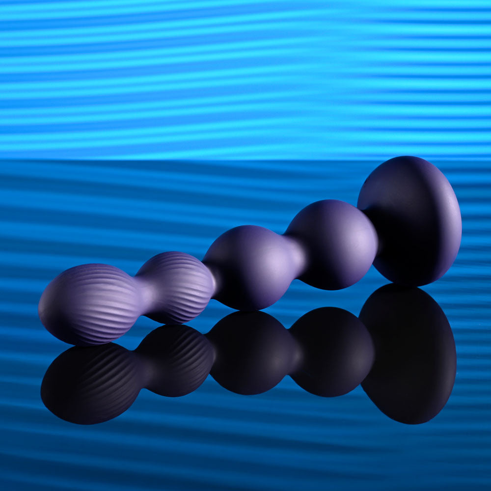 Evolved PLEASURE ORBIT - Navy 17.8 cm USB Rechargeable Twirling & Vibrating Anal Beads with Remote on reflective surface