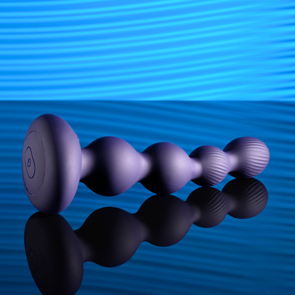 Evolved PLEASURE ORBIT - Navy 17.8 cm USB Rechargeable Twirling & Vibrating Anal Beads with Remote on a reflective surface.