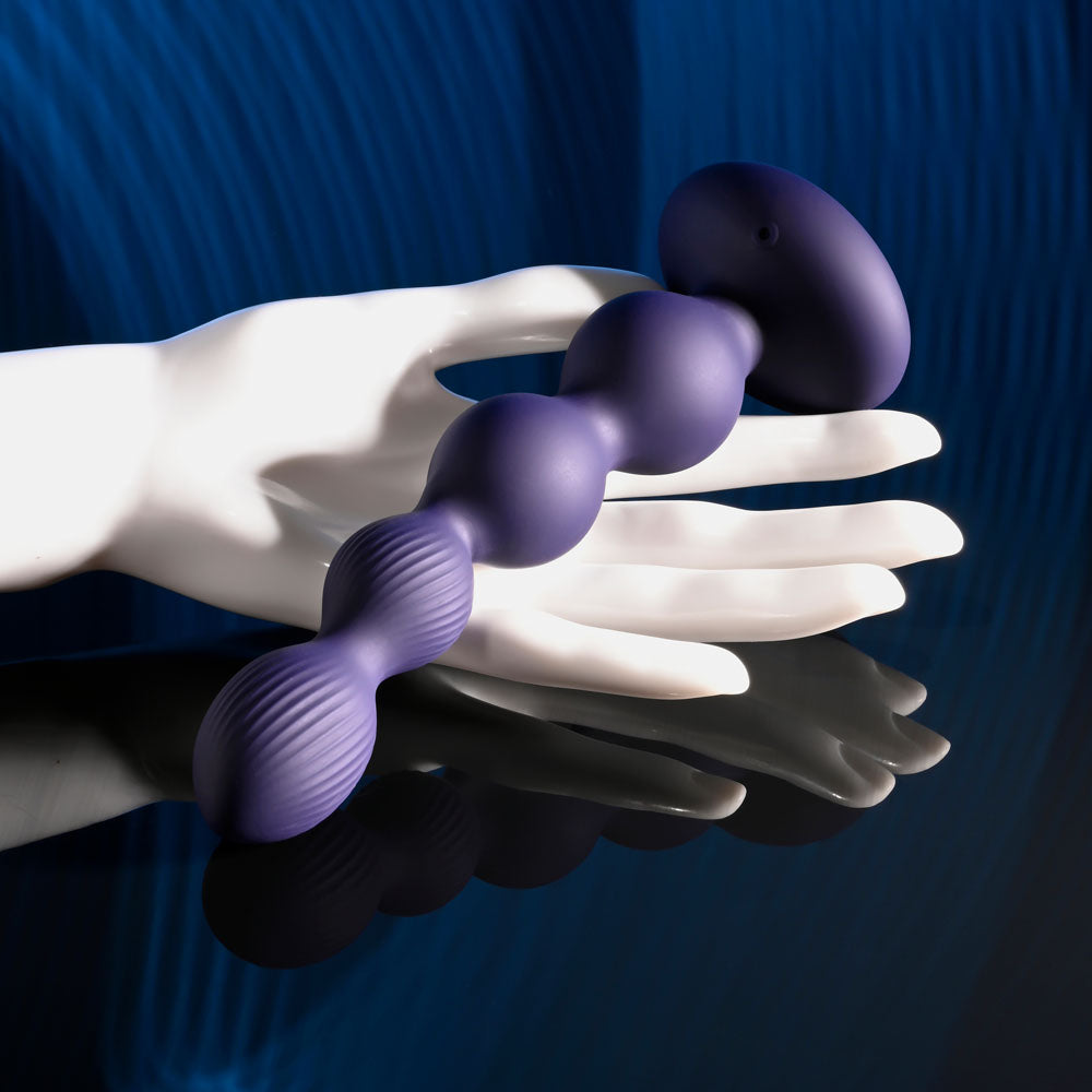 Evolved PLEASURE ORBIT - Navy 17.8 cm USB Rechargeable Twirling & Vibrating Anal Beads with Remote displayed on a hand.
