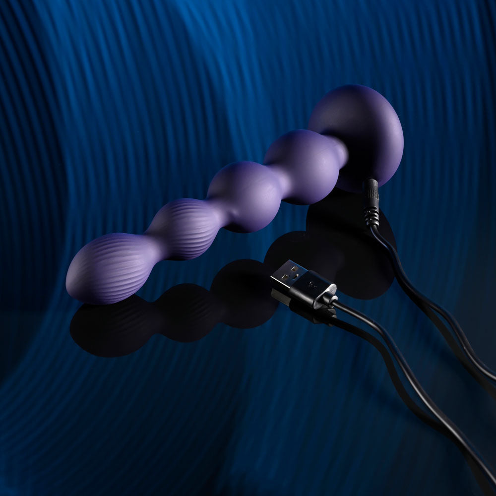 Evolved PLEASURE ORBIT - Navy  17.8 cm USB Rechargeable Twirling & Vibrating Anal Beads with Remote on a reflective surface.