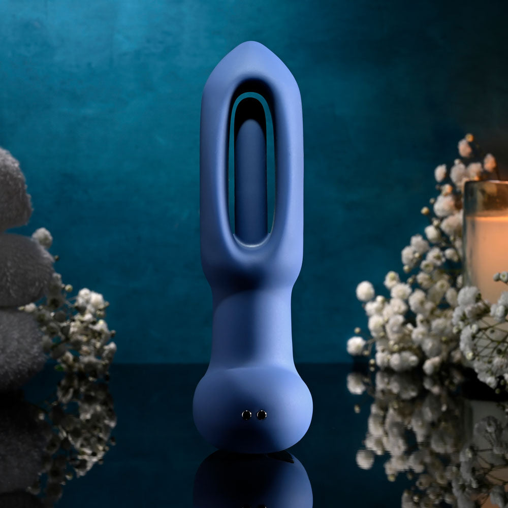 Evolved THE FLAPPER - 14 cm USB Rechargeable Vibrating and Flapping Butt Plug with Remote in blue, surrounded by flowers.