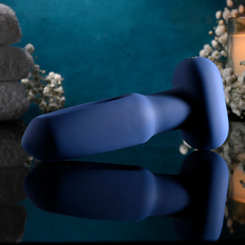 Evolved THE FLAPPER - 14 cm USB Rechargeable Vibrating and Flapping Butt Plug with Remote on a reflective surface.