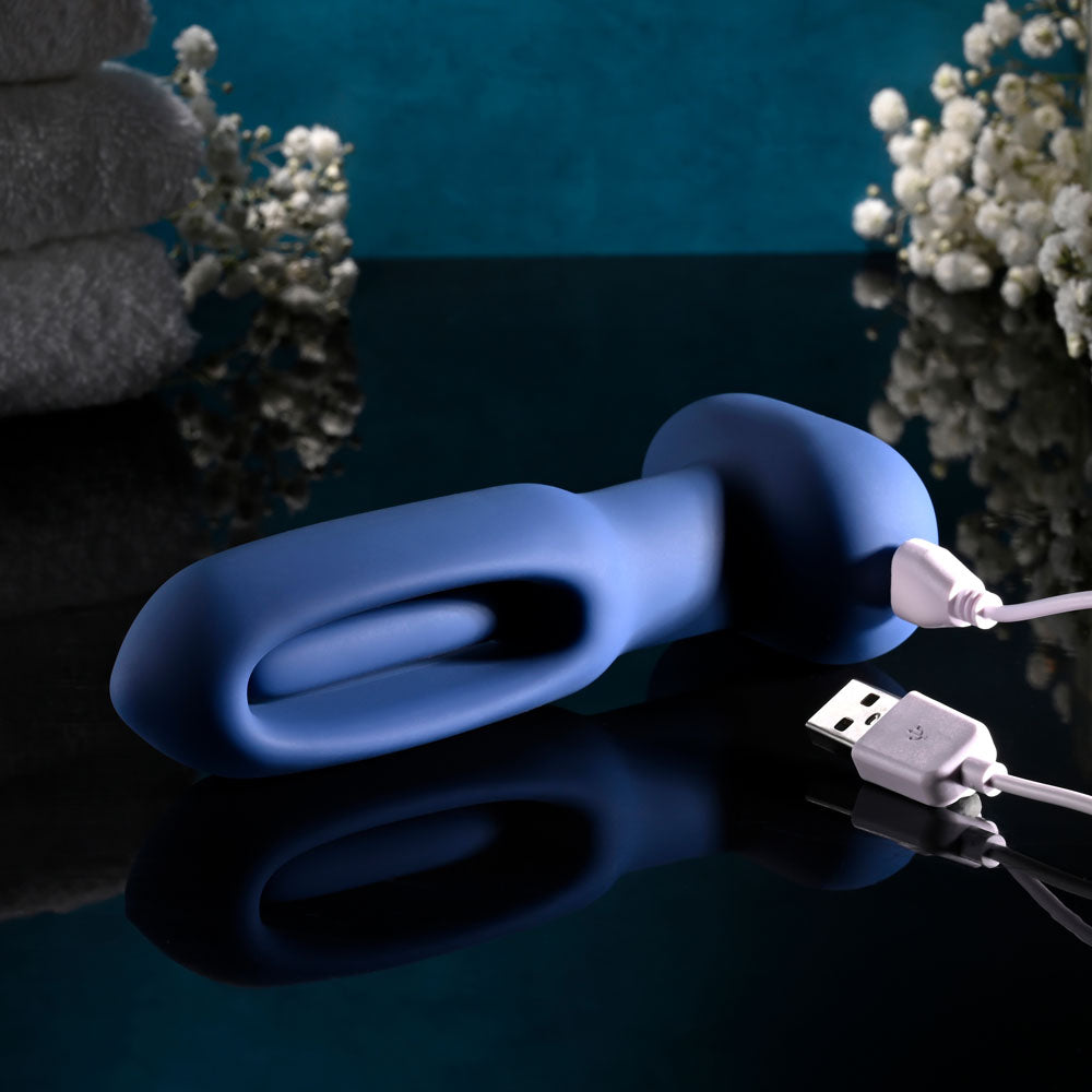 Evolved THE FLAPPER - 14 cm USB Rechargeable Vibrating and Flapping Butt Plug with Remote on a reflective surface.