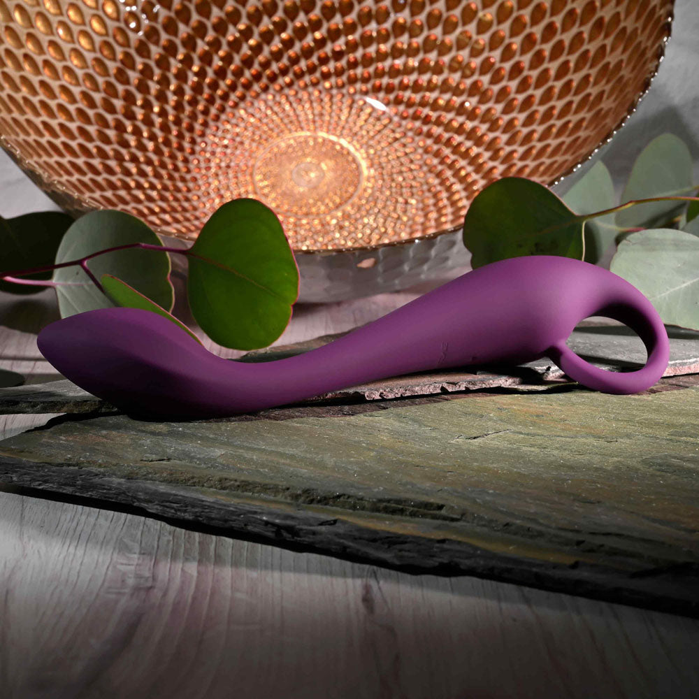 Evolved LOCHNESS G - 19 cm USB Rechargeable Vibrator resting on a stone surface with decorative lighting.