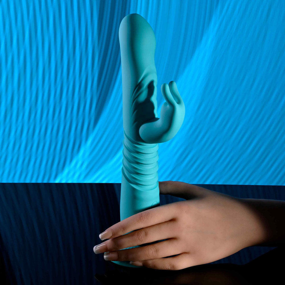 Evolved BUNNY HOP - Teal 25.1 cm USB Rechargeable Thrusting Rabbit Vibrator with Suction Base displayed with a hand.