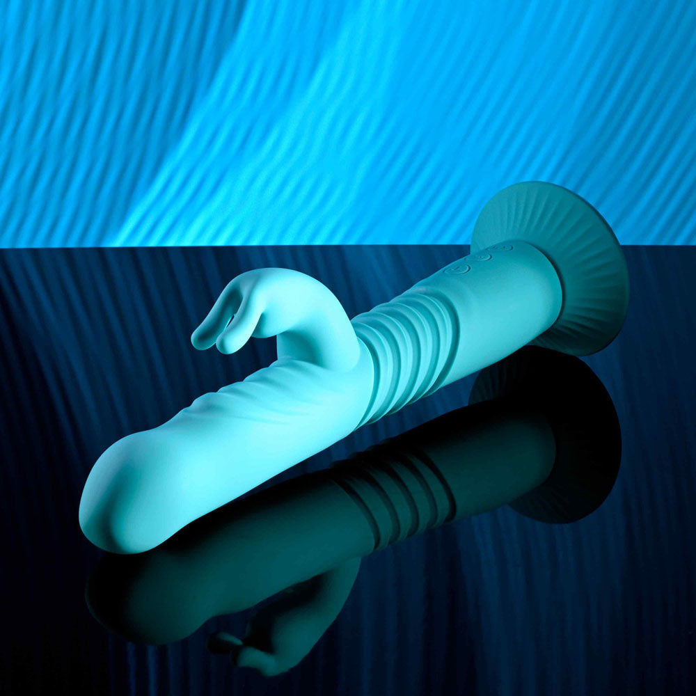 Evolved BUNNY HOP - Teal 25.1 cm USB Rechargeable Thrusting Rabbit Vibrator with Suction Base on reflective surface.