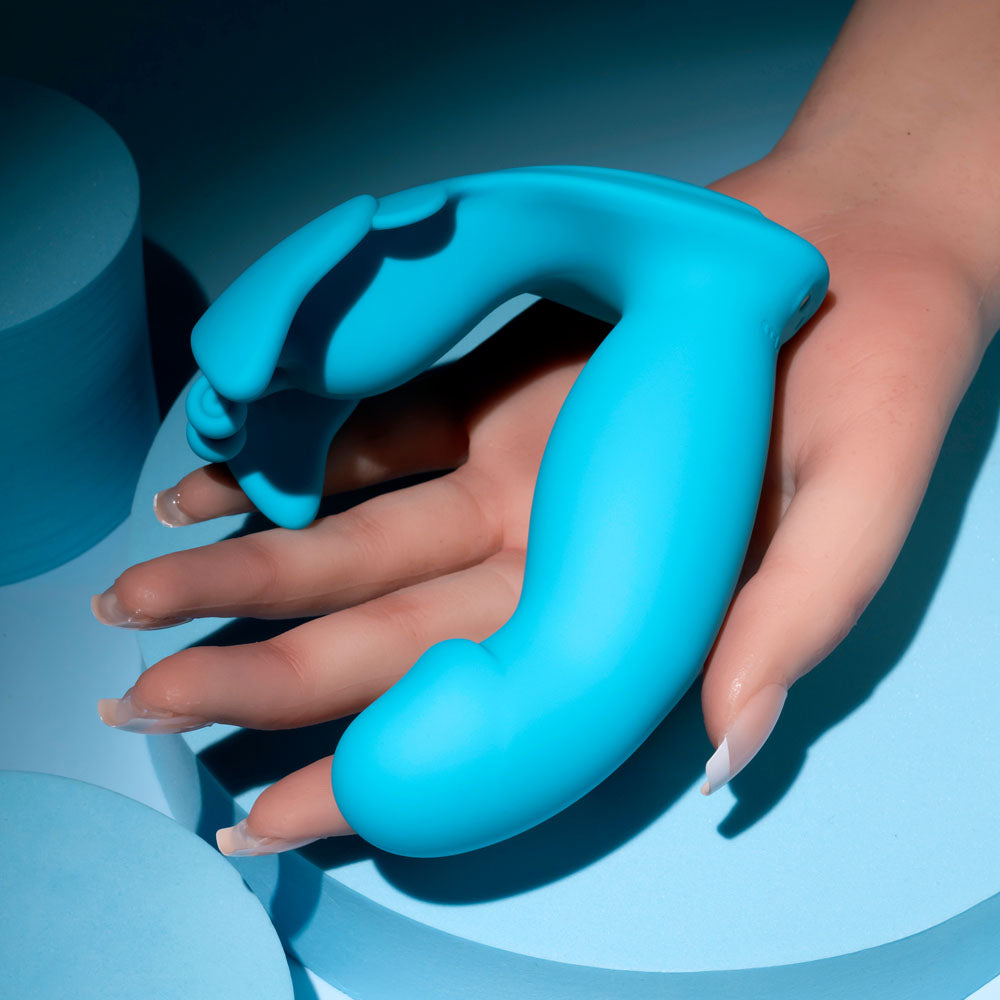 Evolved SPREAD YOUR WINGS -  USB Rechargeable Wearable Butterfly Vibrator held in a hand against a blue background.