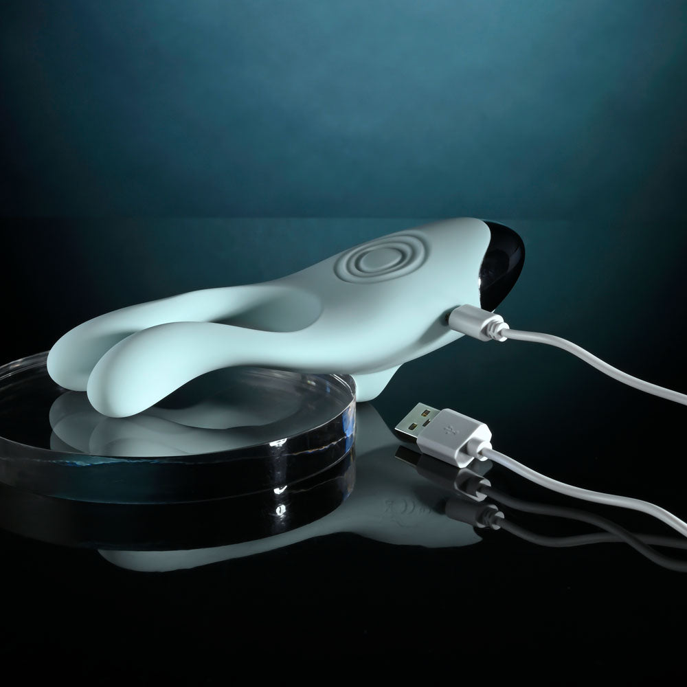 Evolved COUPLES THERAPY - Teal USB Rechargeable Couples Stimulator with charging cable on a glass surface.