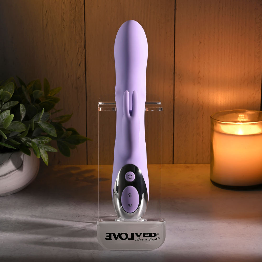 Evolved SPINDERELLA -  USB Rechargeable Rabbit Vibrator displayed elegantly with decorative plants and candle in soft lighting.