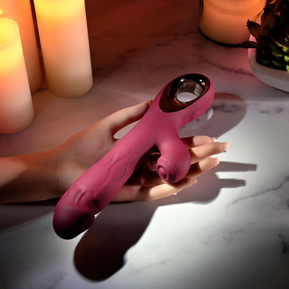 Evolved BURSTING WITH PLEASURE - 25.4 cm USB Rechargeable Vibrator with Tapping Clitoral Stimulator on a marble surface.