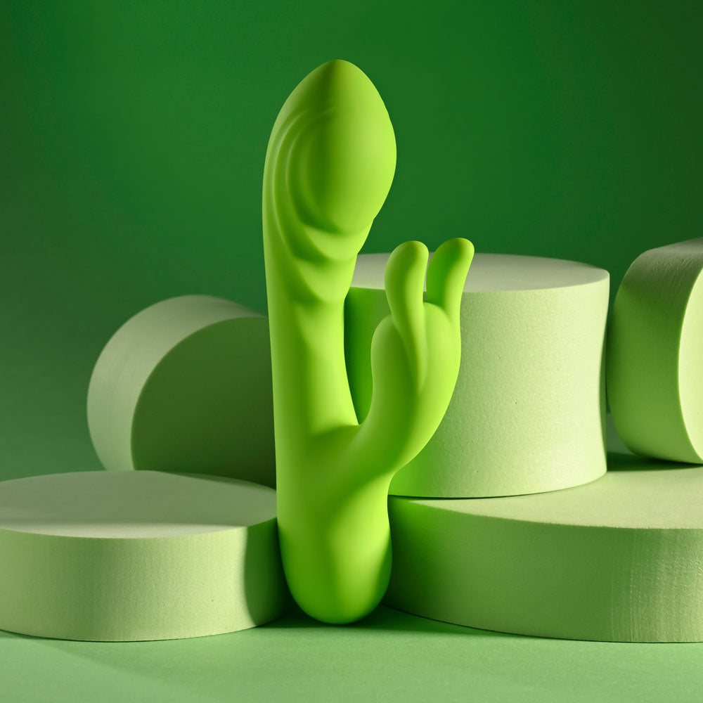 Evolved BRAT BUNNY -  16.2 cm USB Rechargeable Rabbit Vibrator on a green background with soft foam pieces.