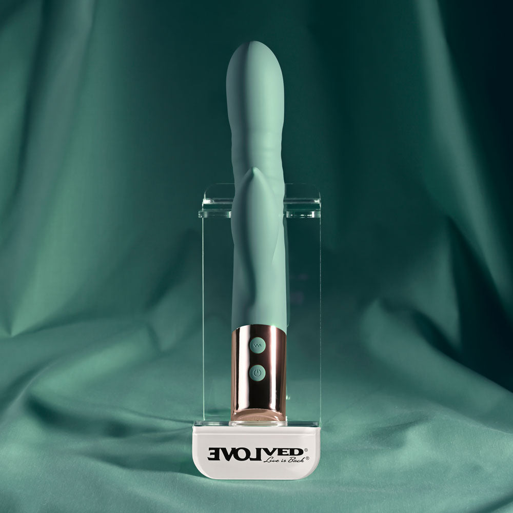 Evolved THE SHIMMY - USB Rechargeable Thrusting Rabbit Vibrator displayed on a soft green background, showcasing its sleek design.