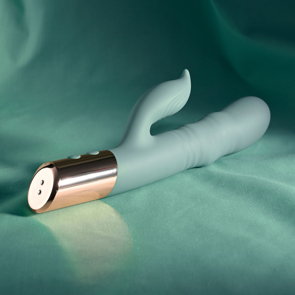 Evolved THE SHIMMY - USB Rechargeable Thrusting Rabbit Vibrator on a teal background, showcasing its sleek design and buttons.