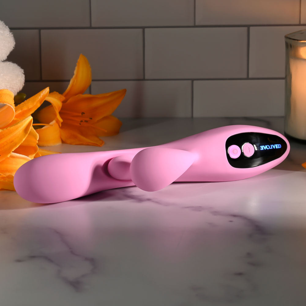 Evolved PUSH THE BUTTON - 23.5 cm USB Rechargeable Rabbit Vibrator with G-Spot Bud on a countertop with flowers.