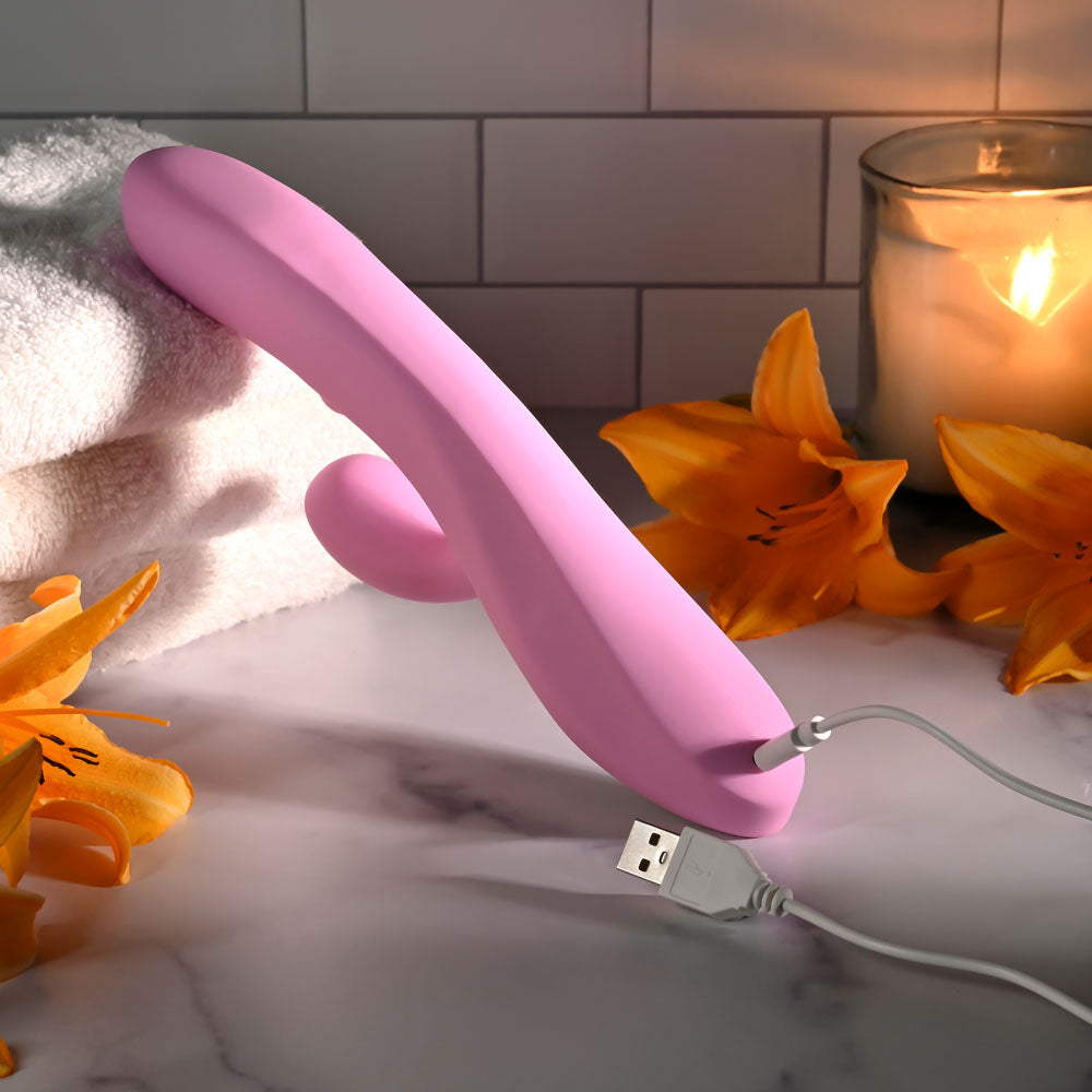 Evolved PUSH THE BUTTON - 23.5 cm USB Rechargeable Rabbit Vibrator with G-Spot Bud surrounded by flowers and towels.